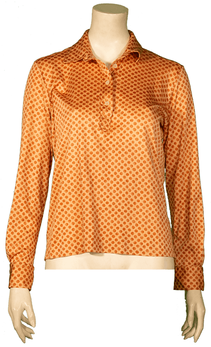 Orange polka dot long-sleeve shirt on mannequin for vintage fashion display