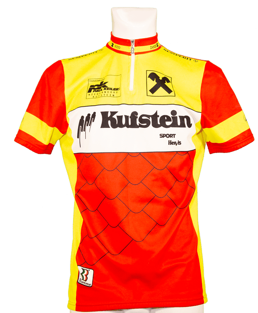 "Brightly colored cycling jersey with red, yellow, and white patterns, featuring Kufstein and sponsor logos."