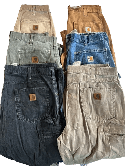 Vintage wholesale Carhartt carpenter pants in various colors stacked, showcasing durable double knee design from the 70s to 00s.