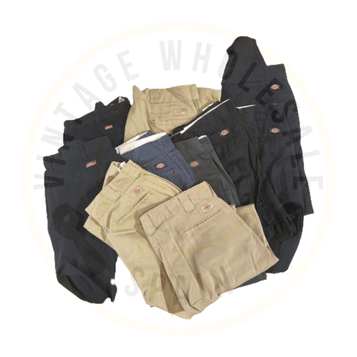 A collection of vintage Dickies pants in various colors piled together.