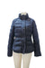 Navy blue puffer jacket on a mannequin, featuring a high collar and zippered pockets.