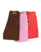 Three pairs of colorful jeans in brown, pink, and red arranged side by side.