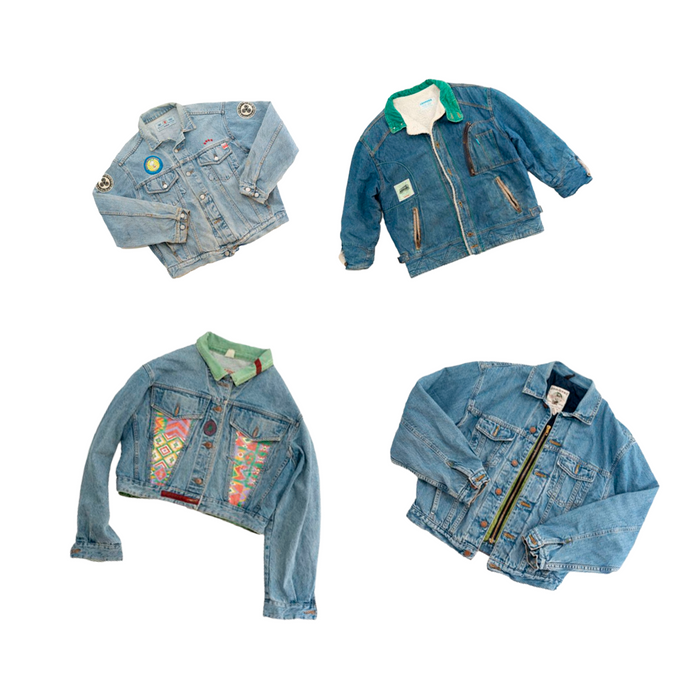 Four unique vintage denim jackets with colorful designs and patches arranged in a flat lay.